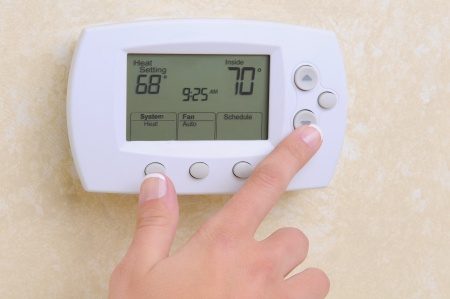 Hand turning down thermostat